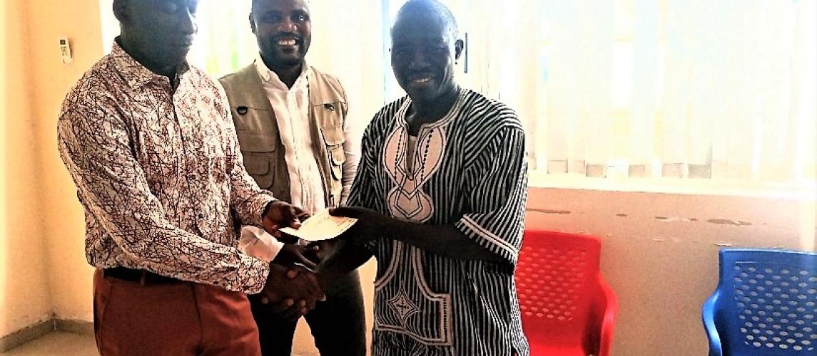 Minister of Transport, Hon. Samuel A. Wlue presenting a check to NAFOMTAL
